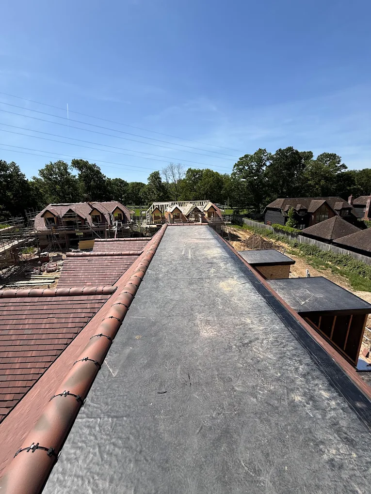 Large EPDM flat roof running alongside a tiled pitched roof on a new build