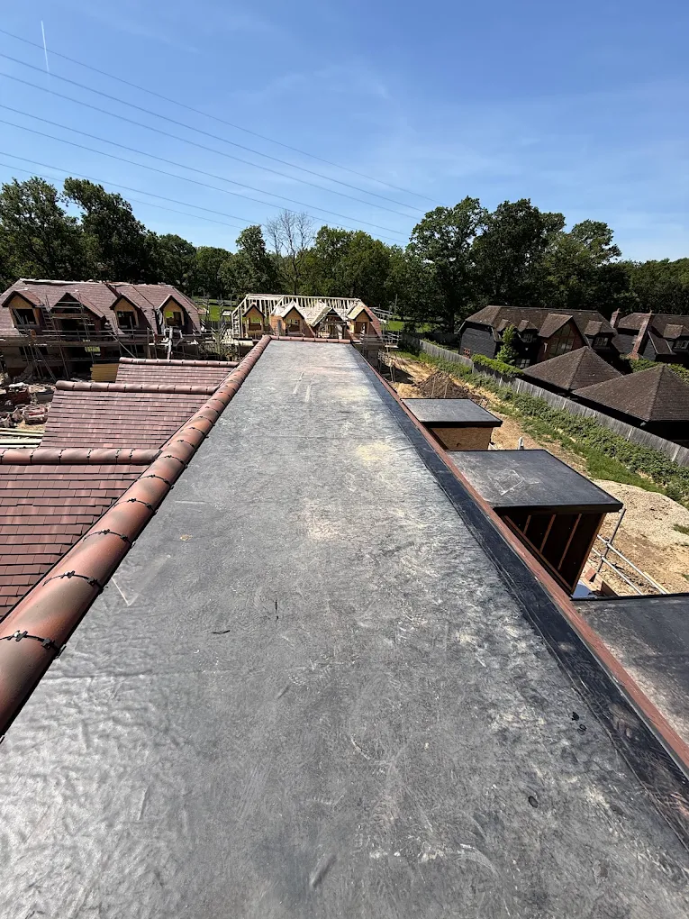 Flat roof deck running past dormer boxes on a new build