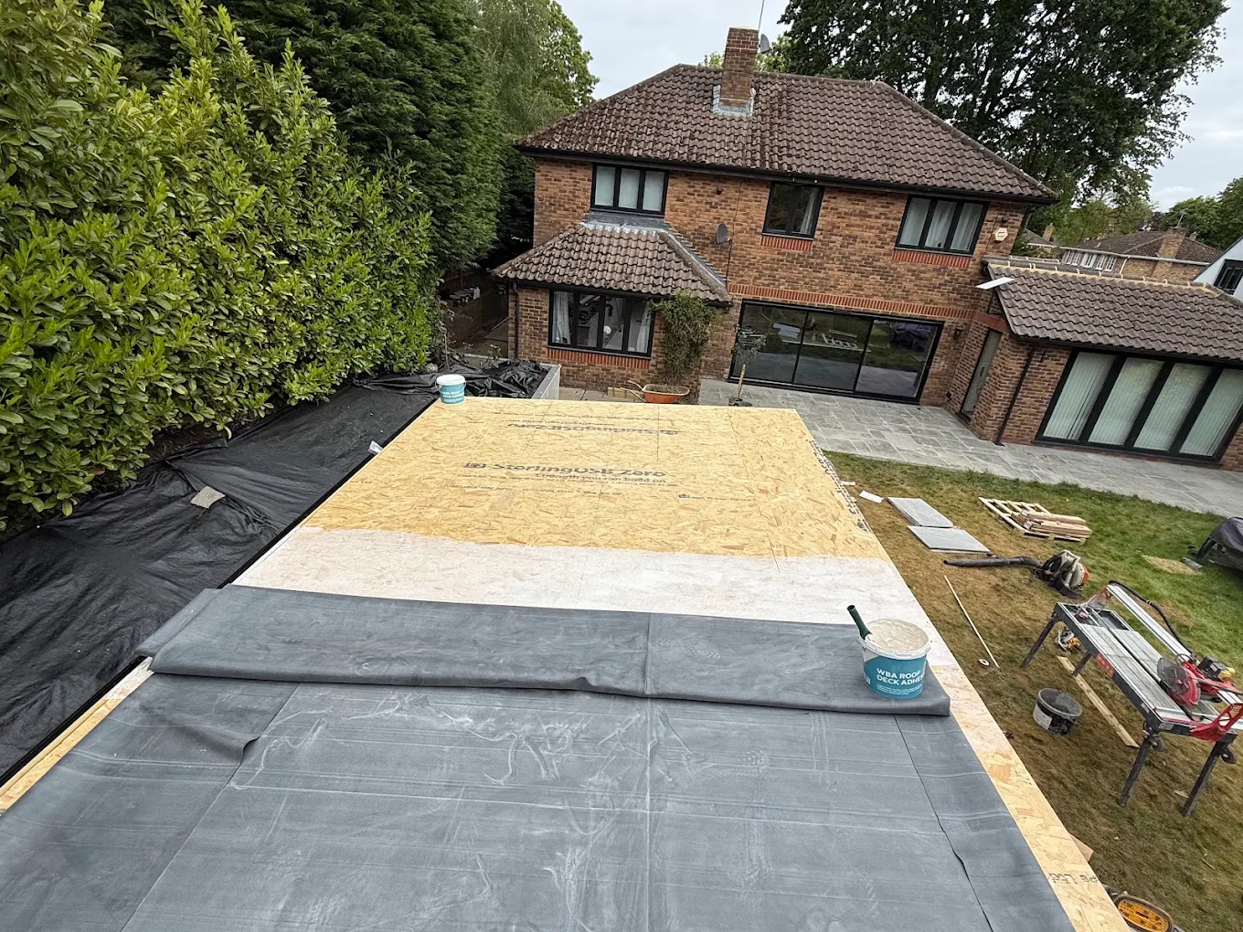 Finished EPDM flat roof on a rear extension behind a large detached house